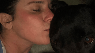 Deb kissing her dog Braidy.