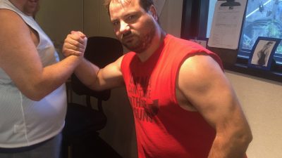 Jason and Nick in the studio shaking hands and look looks at the camera while Jason looks at producer Nick.