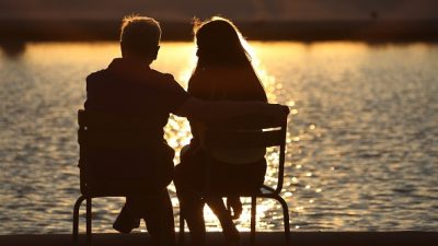 Couple in sunset in front of water