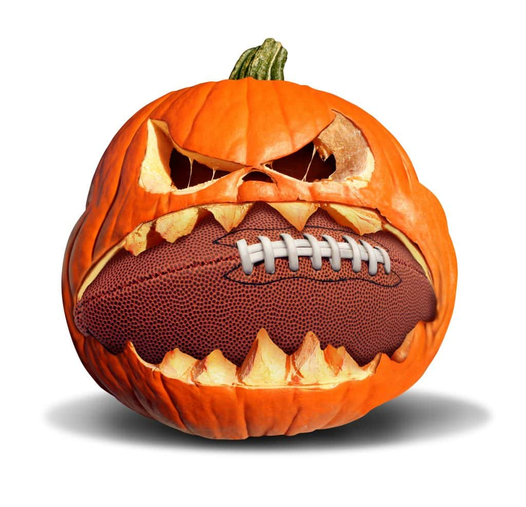 Shutterstock Image of a pumpkin with a football in its mouth.