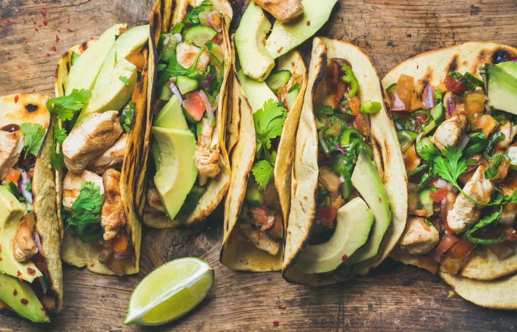 Five tacos with cilantro and lime.