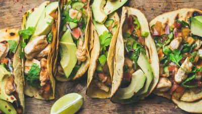 Five tacos with cilantro and lime.