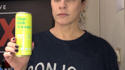 Deb holding up a can of eboost energy drink with a wide-eyed look on her face