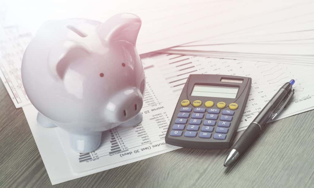 a financial planning set up with a piggy back, calculator, pen