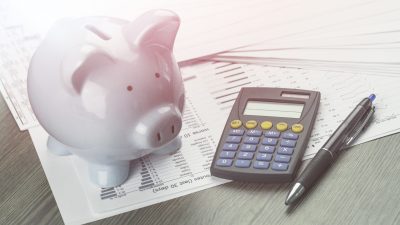 a financial planning set up with a piggy back, calculator, pen