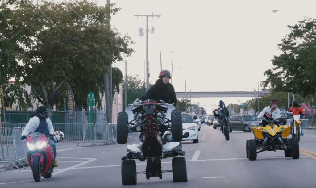 people riding atvs on a street