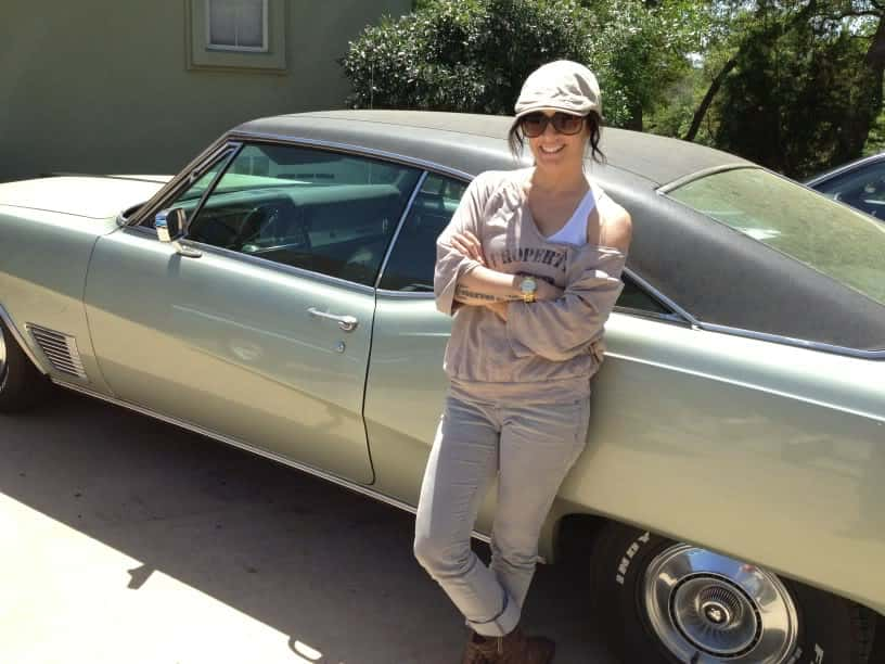 Deb standing in front of her classic Buick Wildcat muscle car