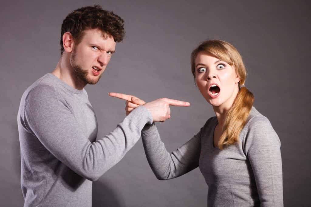 stock image of an arguing couple pointing fingers at each other