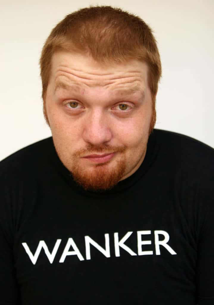 jason making a weird face wearing a shirt that says wanker on it