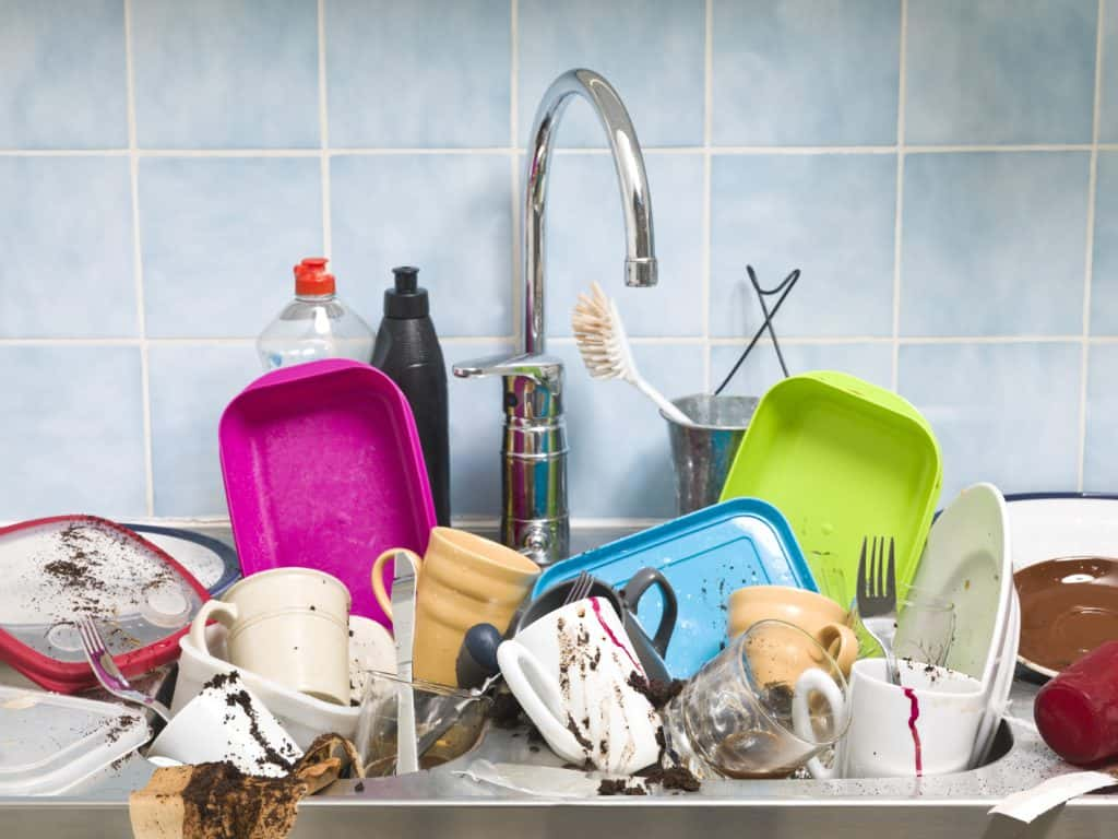 a stock photo of a bunch of dirty dishes piled in a sink