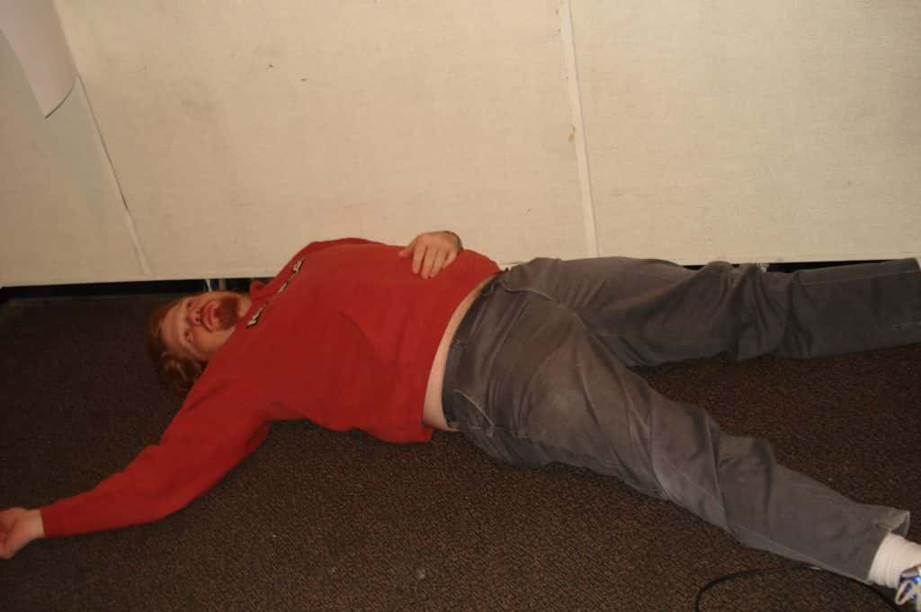 jason dick lying down on the studio floor with a blank look in his eyes