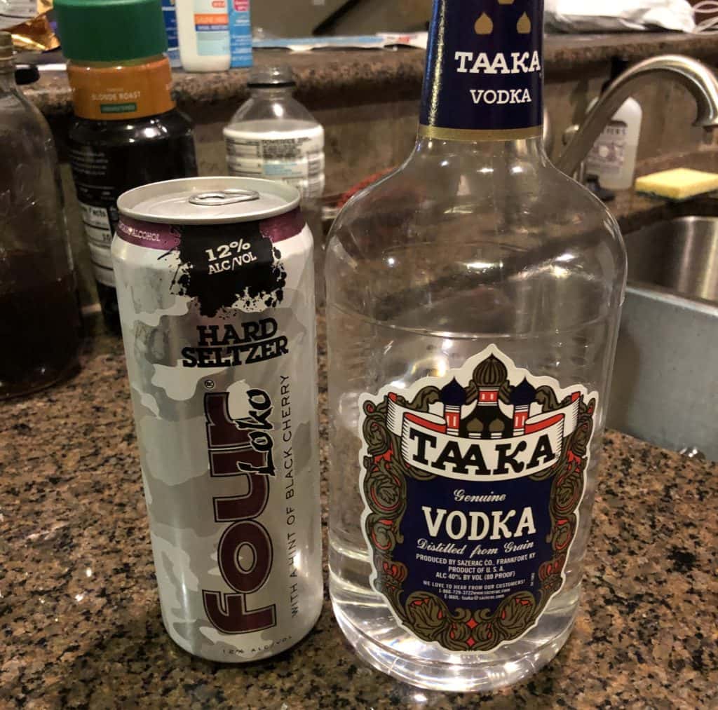 a bottle of cheap vodka and a tall boy can of four loko hard seltzer