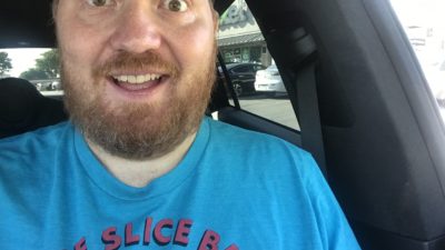 Jason in his car looking excited for pizza party friday