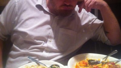 jason doing a sexy pose with two plates of pasta in front of him