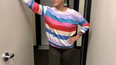 Deb in the studio hallway wearing her multicolored shirt from instagram