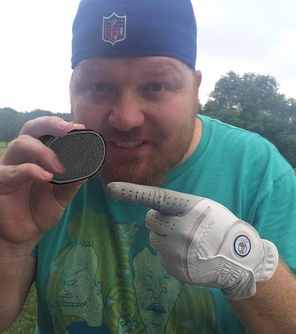 jason holding a bluetooth speaker on the golf course