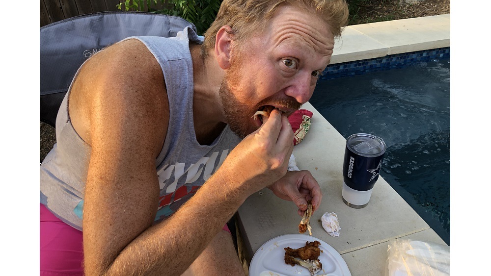 jason stuffing his face with chicken wings at his pool