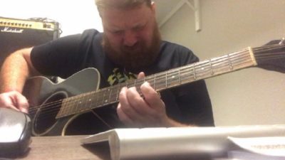 jason playing the guitar in his home office slash closet