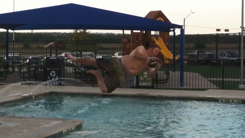 jason catching a football while jumping into the pool at the round rock express stadium