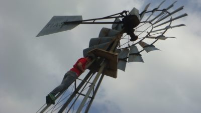 Deb climbing a windmill to fix it
