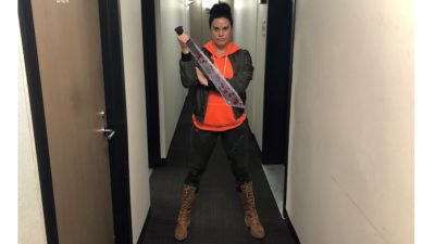 deb wearing her zombie apocalypse outfit consisting of a bright orange hoodie, camo leggings, and boots that go up to her knees