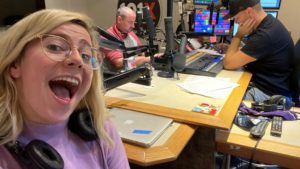 katy taking a selfie in studio with nick and jason not paying attention in the background
