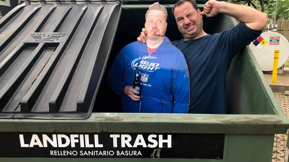 nick standing in the dumpster with a cardboard cut out of jason