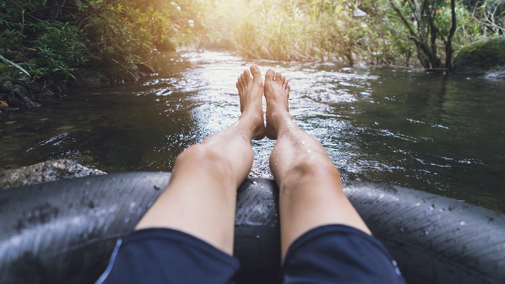 stock photo of a guy tubing the river