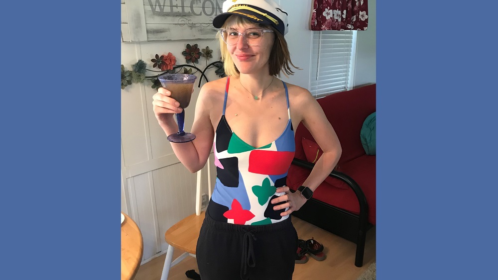 bumblina in a bathing suit, captain's hat holding a glass of sangria