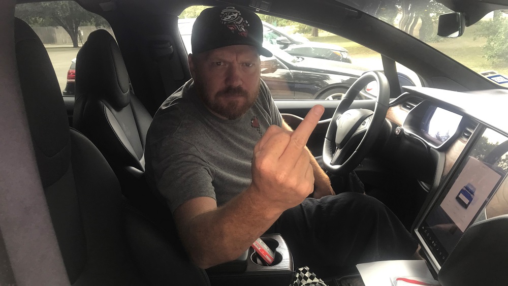 jason flipping the bird from the drivers seat of his tesla