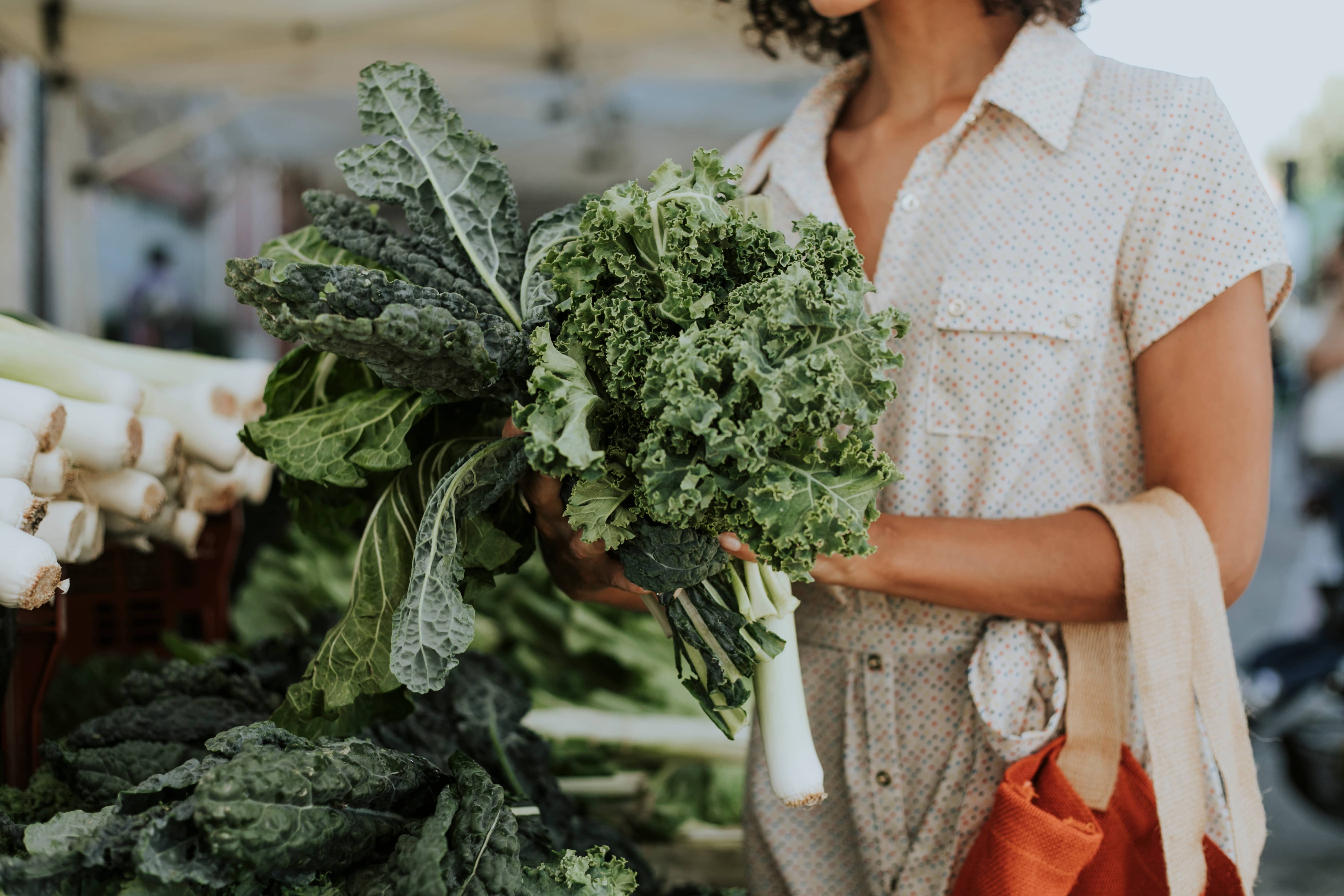 Women buying kale at a farmers market. 
