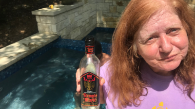 Jason's mom standing next to a pool holding a rumple bottle