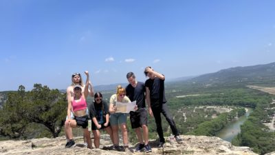 Emily and friends posing on the top of a mountain