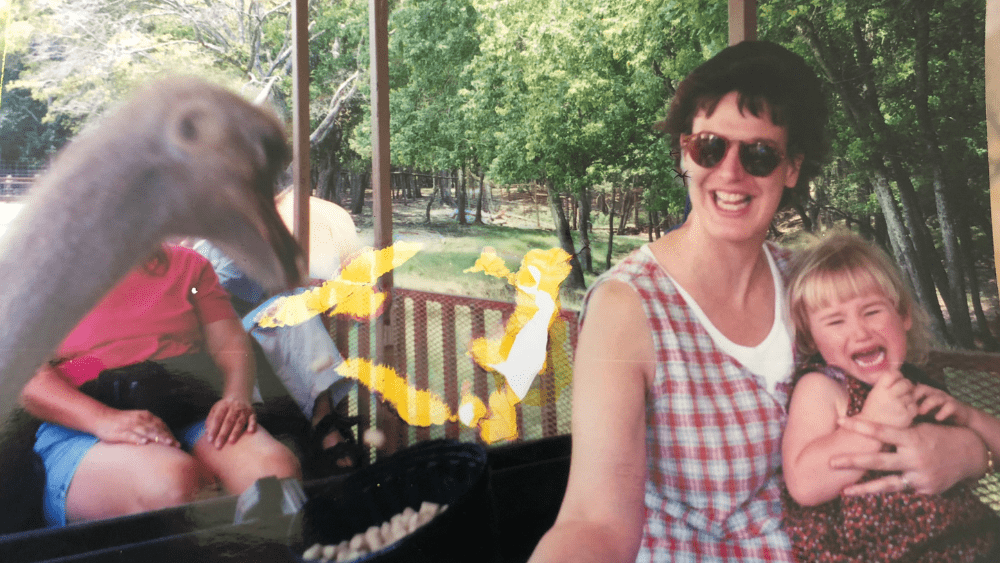 Photo of Emily as a child screaming at a bird with her mom at the zoo