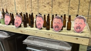 pictures of jason's face taped to bottles in a rage room