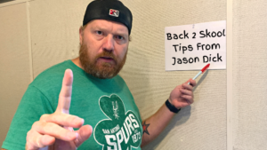 Jason pointing at a sign that says Back 2 Skool Tips from Jason Dick