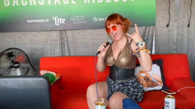 Emily throwing up a rock and roll handsign while holding a microphone at our 101X Backstage hideout at ACL Fest