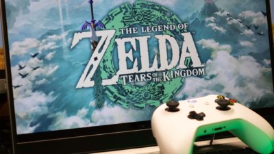 Screen with "Legend of Zelda Tears of the Kingdom" playing with a controller. Image provided by shutterstock