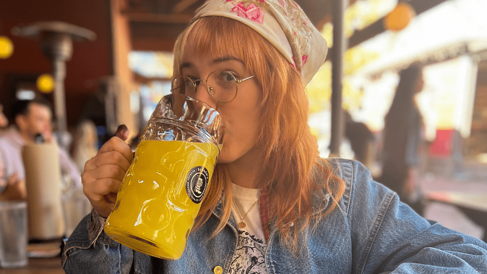 Emily drinking a massive mug of orange juice.