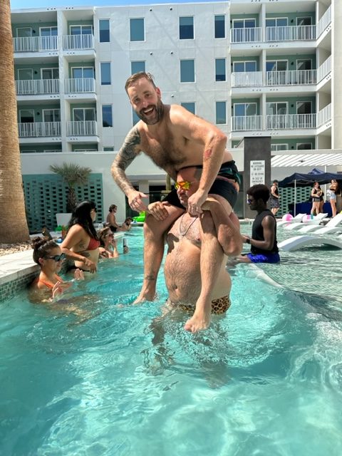 nick and cj morgan in the pool playing chicken at the 101x pool party