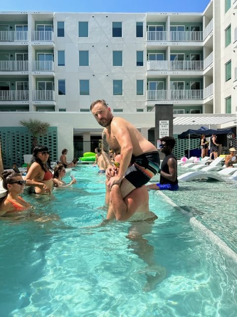 nick and cj morgan in the pool playing chicken at the 101x pool party