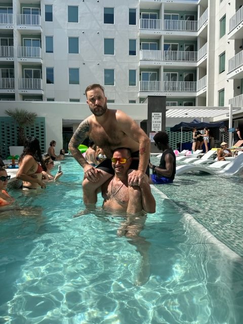 nick and cj morgan in the pool playing chicken at the 101x pool party