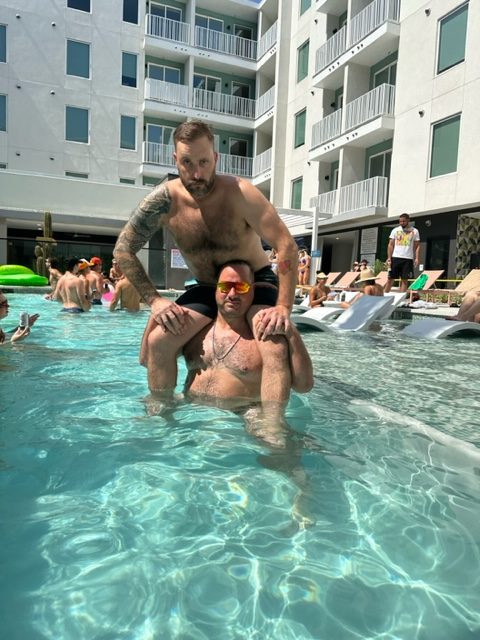 nick and cj morgan in the pool playing chicken at the 101x pool party