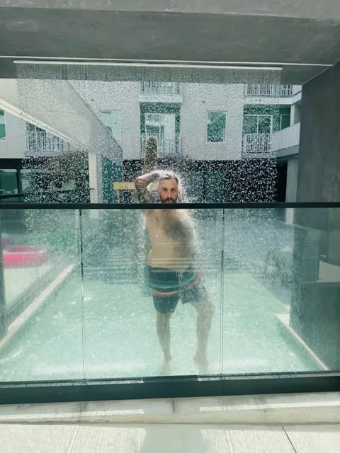 cj morgan standing under a waterfall looking sexy at the 101x pool party 