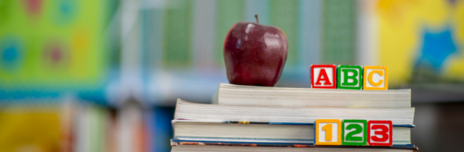 Image provided by shutterstock. ABC blocks on top of books with an apple