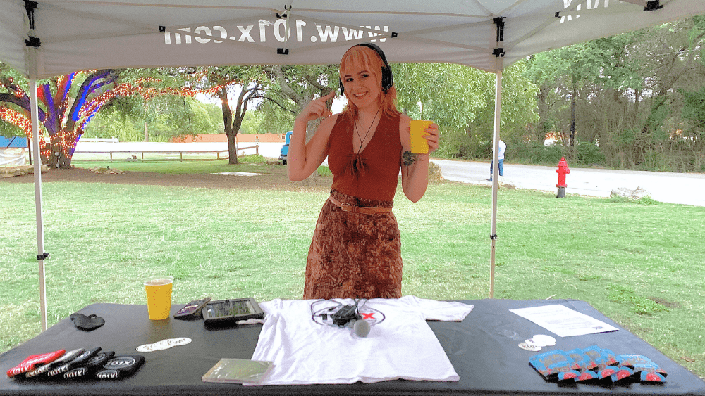 Emily with headphones under a 101x tent at an event