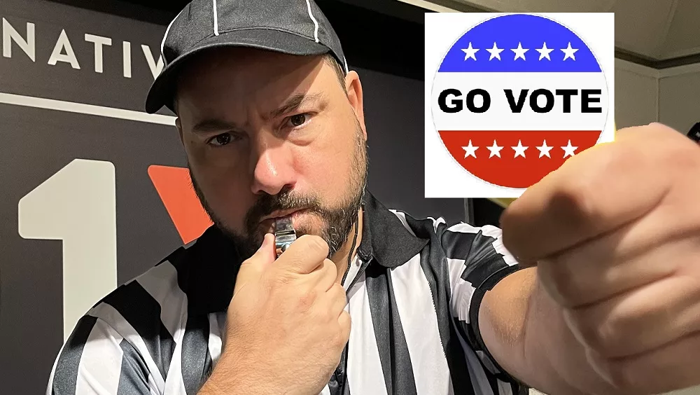 Nick dressed as a referee holding a go vote sticker