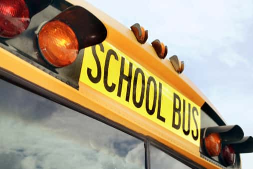 The front of a school bus with red lights and the word "School Bus" on it. Photo by Thinkstock/Thinkstock.