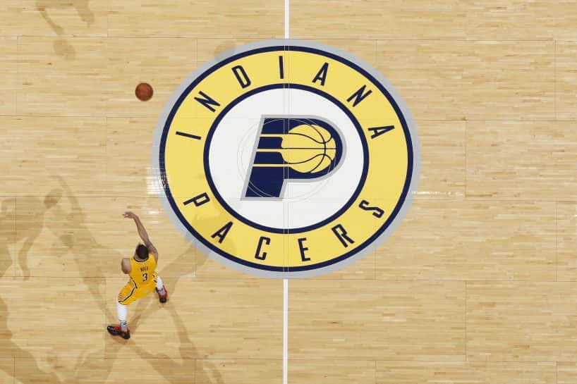 The Pacers logo on a basket ball court with a player running around. (Photo by Joe Robbins/Getty Images)