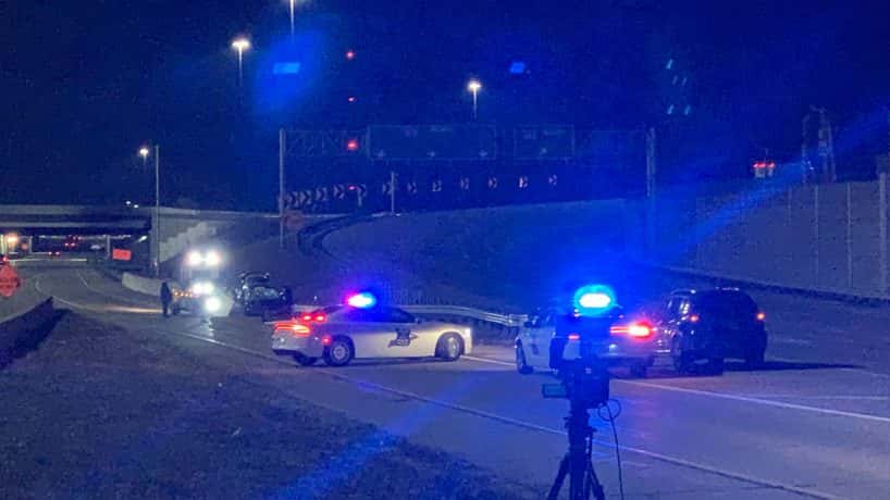 Police cars with their lights on around a crash